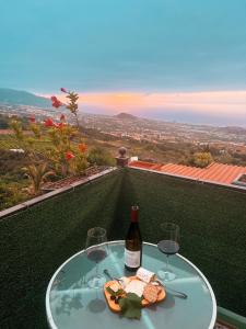 een tafel met twee glazen en een fles wijn bij Sun-soaked apt w patio, balcony & garden - Aguilas in La Orotava