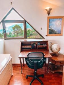 a desk with a chair in a room with a window at Sun-soaked apt w patio, balcony & garden - Aguilas in La Orotava