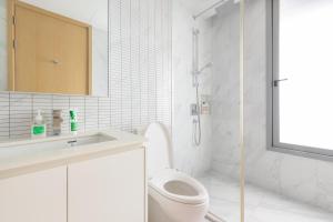 a white bathroom with a toilet and a sink at Skyline Suites Sukhumvit 11 in Bangkok +79 photos