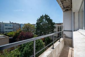 - un balcon dans un bâtiment avec des arbres et des bâtiments dans l'établissement *Face à la mer* Malo-les-bains, à Dunkerque