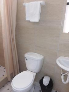 ein Badezimmer mit einem weißen WC und einem Waschbecken in der Unterkunft Hospedaje Moralillos in Yurimaguas