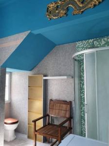 La salle de bains est pourvue d'une chaise en bois et de toilettes. dans l'établissement Villa Eclettica A POCHI METRI DAL MARE, à Pesaro