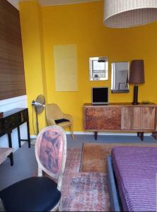 a yellow room with a bed and a table and chairs at Villa Eclettica A POCHI METRI DAL MARE in Pesaro