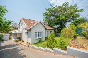 a white house with a yard at Danville Forest Villa in Durban