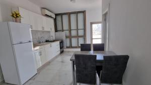 uma cozinha com um frigorífico, uma mesa e cadeiras em New Stylish Apartment with Balcony Close to Tel Aviv em Bene Beraq