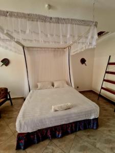 uma cama branca com dossel num quarto em GKAT Resort em Mbarara