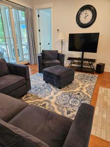 a living room with a couch and a flat screen tv at Low Country Cottage in Beautiful Habersham in Beaufort