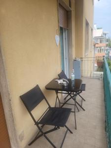 een balkon met 2 stoelen en een tafel met een laptop bij Casa Dany in Albissola Marina