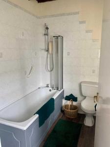 a white bathroom with a tub and a toilet at Stunning Cottage in Kilmun Argyll - sleeps 2 in Dunoon