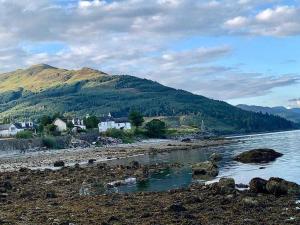 a body of water with houses and a mountain at Stunning Cottage in Kilmun Argyll - sleeps 2 in Dunoon