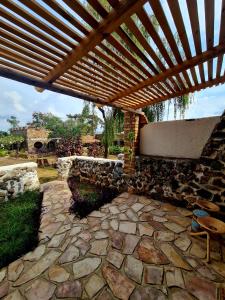 een stenen patio met een houten pergola bij GKAT Resort in Mbarara