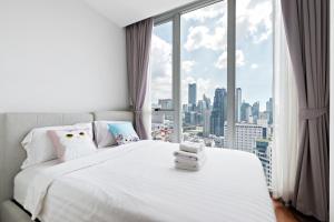 曼谷的住宿－Hyde Sukhumvit 11 by LeFoyer，卧室配有白色的床和大窗户