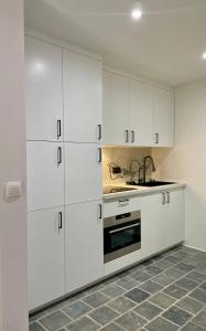 a kitchen with white cabinets and a sink at Residentie Don in Bruges