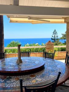 a patio with a table and chairs and the ocean at Marine Park Casa Vacanze in Scifo