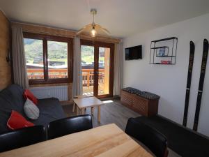 a living room with a couch and skis on the wall at Appartement Confort 4 Pers, Balcon Sud, Proche Pistes et Commerces, WIFI Inclus - FR-1-502-406 in Tignes