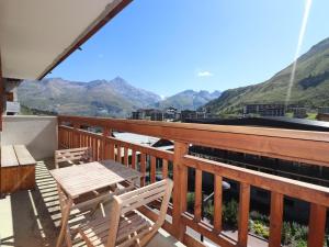 a balcony with a table and chairs and mountains at Appartement Confort 4 Pers, Balcon Sud, Proche Pistes et Commerces, WIFI Inclus - FR-1-502-406 in Tignes