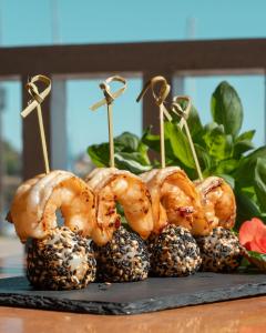 a group of shrimp on bamboo skewers on top of pine cones at Naval Guest House & Bistrô in Vila do Conde