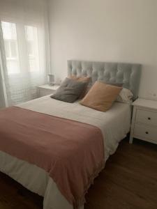 - une chambre avec un grand lit et 2 fenêtres dans l'établissement Coqueto apartamento en Gijon, à Gijón