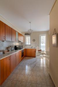 a large kitchen with wooden cabinets and a table at Vanesa's House in Athens
