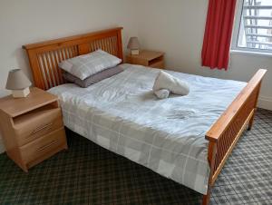Schlafzimmer mit einem großen Bett mit einem Kopfteil aus Holz in der Unterkunft Eglantine Townhouse in Belfast