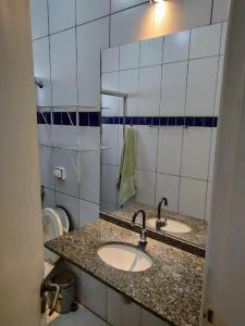 uma casa de banho com 2 lavatórios e um espelho em Casa aconchegante. em Campo Grande