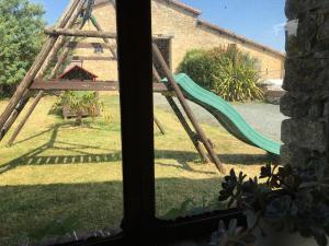 a window view of a yard with a slide at La Frouardière, 3 gîtes de charme in Antigny +40 photos