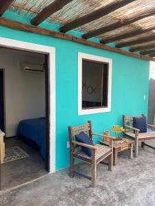 Habitación con una pared azul con 2 sillas y 1 cama en Casa Prainha, en Praia do Frances