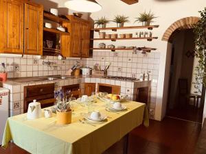 eine Küche mit einem Tisch und einem gelben Tischtuch in der Unterkunft Chianti Home with Pool Terrace Garden and Magnificient View 2 to 8 persons in Greve in Chianti