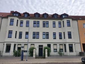 een groot wit gebouw met een rood dak bij NEU! Uni-Nähe! Altbau Apartment, Küche, TV, Balkon in Maagdenburg