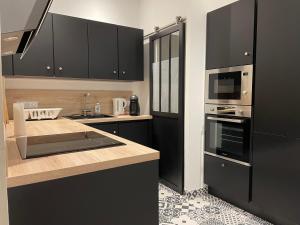 a kitchen with black cabinets and a counter top at UNE TERRASSE SUR LES TOITS in Aix-en-Provence