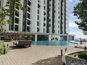a swimming pool in front of a tall building at Comic Homestay @ The Shore in Kota Kinabalu