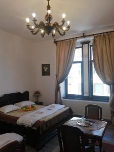 - une chambre avec un lit, une table et un lustre dans l'établissement Casa Continentelor, à Cîmpulung