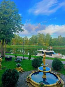 fontanna w środku parku z łodzią w obiekcie Pałac na wodzie Falkowski Medical & SPA & Conference w mieście Augustów