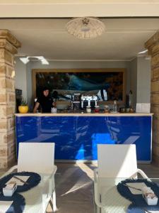 a man standing in a kitchen with a blue counter at Marine Park Casa Vacanze in Scifo