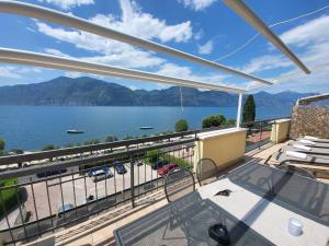 a balcony with a view of the water and mountains at Attico Masse Lake view in Brenzone sul Garda