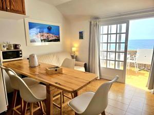sala de estar con mesa de madera y sillas en Brisas del Roque Coastline Apartment in Garachico by HRTenerife Net en Garachico
