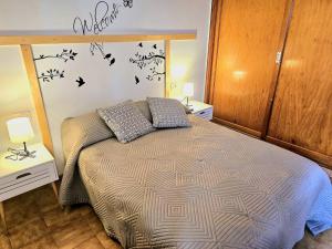 1 dormitorio con 1 cama con pájaros en la pared en Brisas del Roque Coastline Apartment in Garachico by HRTenerife Net en Garachico