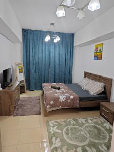 - une chambre avec un lit et un rideau bleu dans l'établissement Perfect Private studio, à Ajman