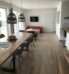 een woonkamer met een tafel en een rode bank bij Les Agapanthes in Noirmoutier-en-l'lle