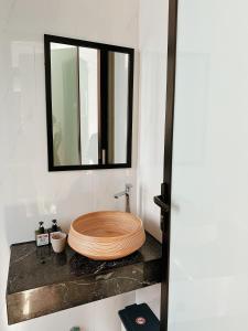 a bathroom with a wooden sink and a mirror at Under the Sun Homestay in Hue