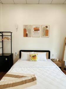 a bedroom with a white bed with a blanket on it at Under the Sun Homestay in Hue