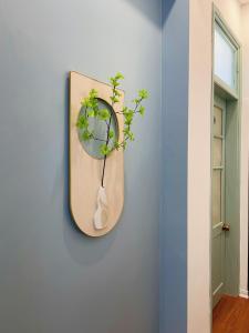 a mirror hanging on a wall with a plant at Under the Sun Homestay in Hue