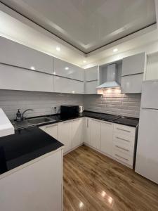 a kitchen with white cabinets and a black counter top at Apartment in Tumanyan street in Yerevan +21 photos