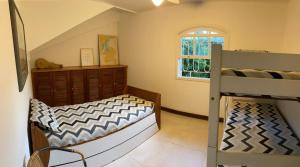 1 dormitorio con 2 literas y ventana en Casa Perequê 100 metros da praia, en Ilhabela