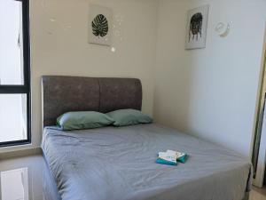 a bed with a book on it in a bedroom at Comic Homestay @ The Shore in Kota Kinabalu +9 photos