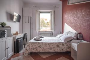 ein kleines Schlafzimmer mit einem Bett und einem Fenster in der Unterkunft B&B Vatican Stories in Rom