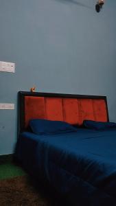 - un lit avec tête de lit bleue et rouge dans la chambre dans l'établissement Manavi Home Stay, à Mathura