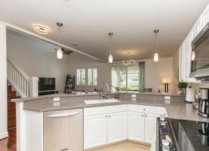 a kitchen with white cabinets and a sink at Ko Olina Kai New Villa Ohana in Kapolei