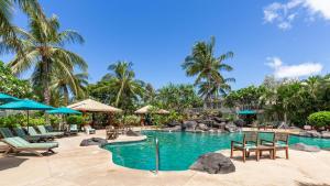 uma piscina num resort com cadeiras e guarda-sóis em Ko Olina Kai New Villa Ohana em Kapolei