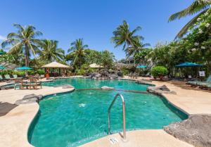 a large swimming pool in a resort with palm trees at Ko Olina Kai New Villa Ohana in Kapolei
